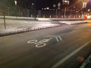 'Shared Lane' marking (sharrow) up close indicates correct lane position for bikes - i.e. right in the middle of the lane. (click to expand.)